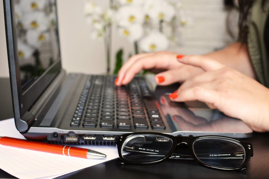 woman working at a laptop. Does your business blog need some of your time?